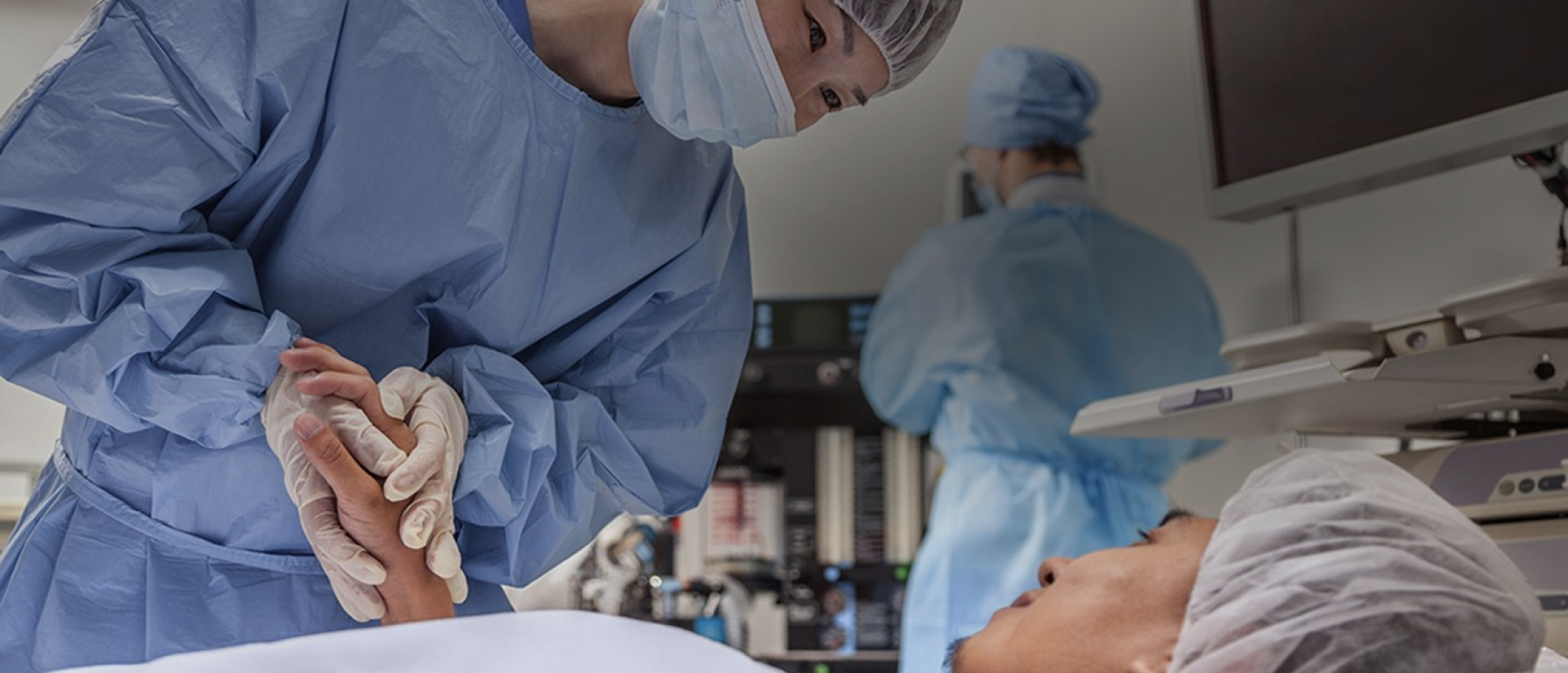 skupina ľudí v modrých laboratórnych plášťoch a maskách